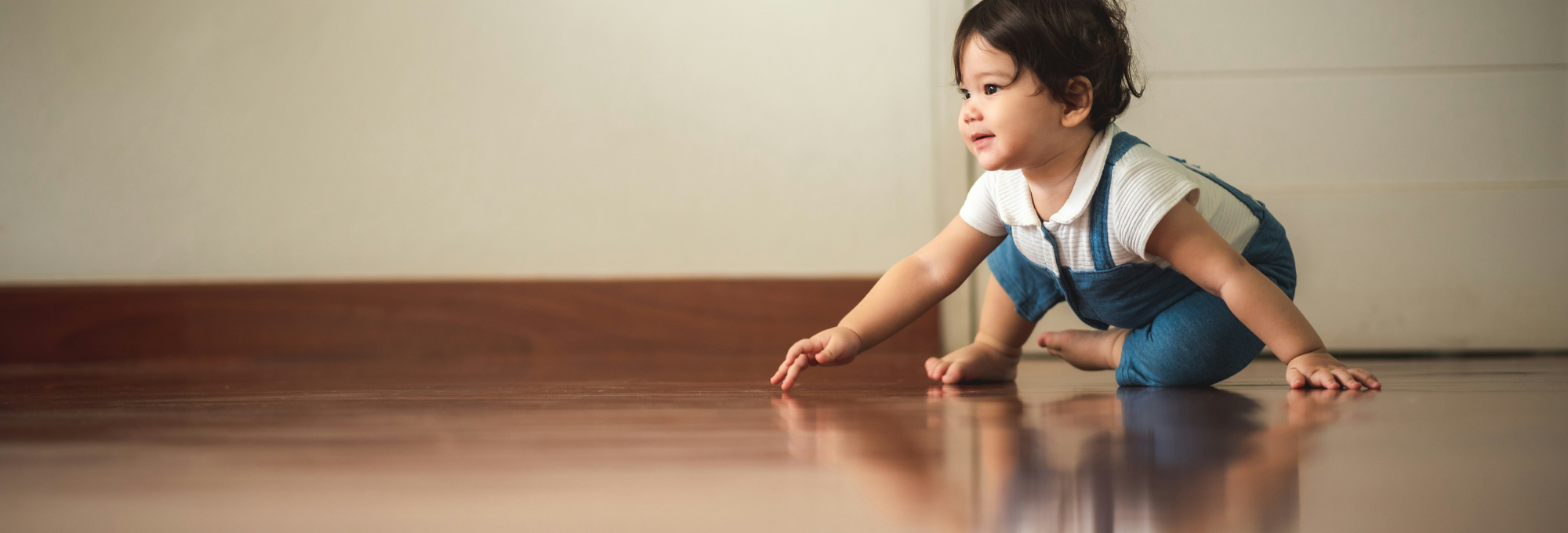 Toddler crawling on a new hardwood floor in a family home
